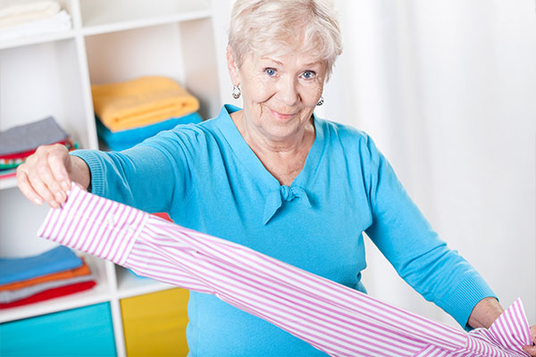 Senioren- & Pflegeheime - Bewohnerwäsche. Hier im Bild: eine nette Helferin, die Wäsche zusammenlegt.